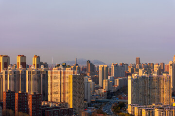 Golden Dusk Over the City Skyline with Mountains © QuachVan