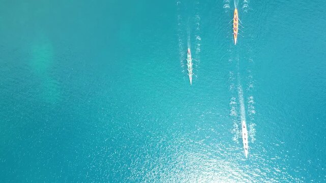 Top Down Aerial View of Rowing Boats Competing in a Race on Turquoise Sea. High quality 4k footage