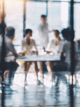 Blurred image of a diverse business team in a modern office meeting room discussing strategy around a table with natural light