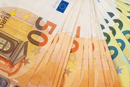 Extreme closeup of euro banknotes texture and microprint, abstract pattern and golden shimmer, detailed security threads and graphic composition for editorial use