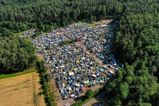 Geiselwind, Germany - 21 June 2025: Aerial view of the Eventzentrum Strohofer Geiselwind musichall campsite with tents surrounded by dense forest under bright daylight.