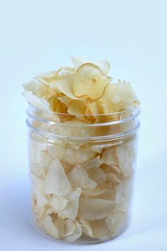 cassava chips or keripik singkong traditional chips from indonesia in an open plastic container, ready to be enjoyed while relaxing, isolated on white background