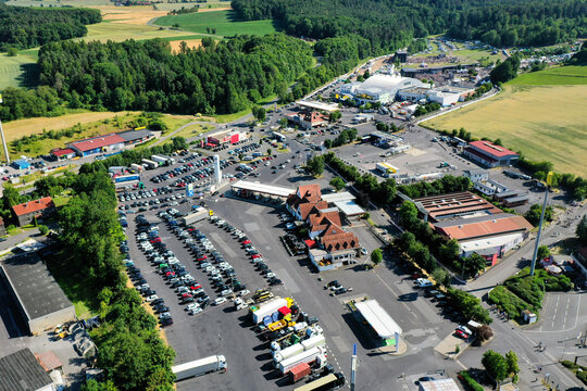 Geiselwind, Germany - 21 June 2025: Aerial view of the Eventzentrum Strohofer Geiselwind musichall complex with extensive parking areas, trucks, and surrounding green landscapes.