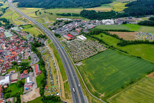 Geiselwind, Germany - 20 June 2025: Aerial view of the Heroes Festival Geiselwind grounds with crowded parking lots next to the Autobahn A3 and green fields.