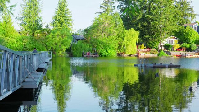 Victoria, British Columba, Canada &ndash; May 23, 2026: Calm lake water with boardwalk and houses