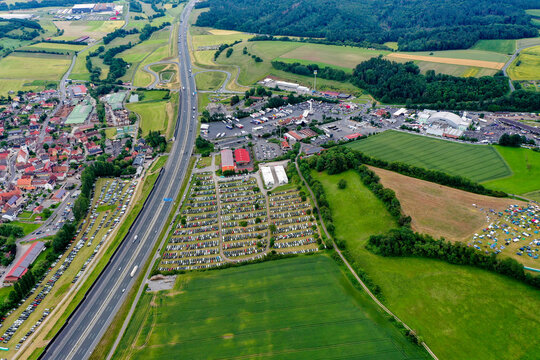 Geiselwind, Germany - 20 June 2025: Aerial view of Heroes Festival Geiselwind with crowded parking lots, the A3 motorway, and lush green fields in the Bavarian countryside.