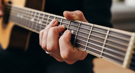 Obraz premium Close up of male hand playing chords on acoustic guitar fretboard