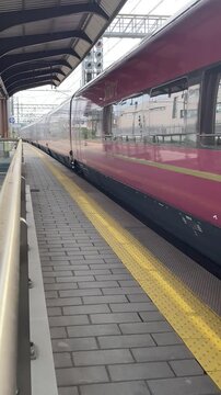 Italy , Florence, March 31st 2026- Vertical video , Italo Hight speed 300km h train railway view from a station the faster way to travel in Italy from Milan to Rome. A1 motorway , cars and train