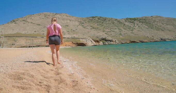 Young Woman Walking on the Pebble Beach of Vela Luka on Krk Island, Croatia