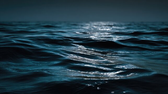 Close-up of Ocean Waves with Sunlight Reflection on Deep Blue Water Surface in a Calm Sea