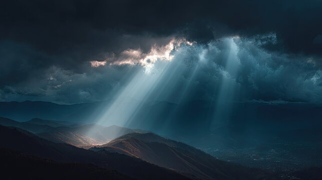 Dramatic clouds and sunbeams breaking through stormy sky over mountain landscape during rainstorm
