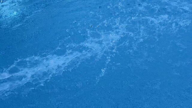 Klares Wasser im Swimmingpool &ndash; Sommerliche Pooloberfl&auml;che mit sanften Wellen in Zeitlupe