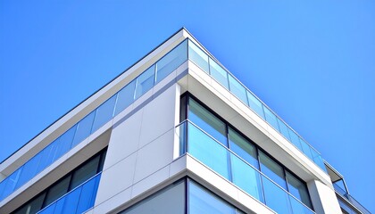 Obraz premium Side perspective of modern building corner with sky background, architectural detail. Clean real estate visual.