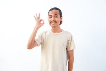 Young Asian man in a shirt, give OK or approved sign expression. Isolated in white background