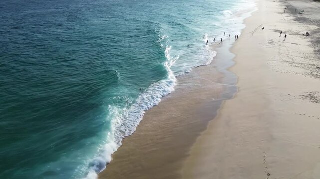 Tropical beach with big waves, with houses near the coast and a mountain range in the background - Saquarema, Rio de Janeiro