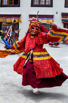 Buddhist monks in vibrant masks and ornate robes perform traditional Cham dance in Ladakh India showcasing spiritual ritual culture and Himalayan heritage.