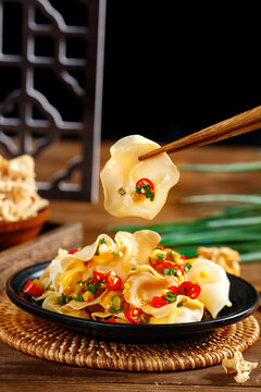Delicious Changbaishan jade fungus cold dish with fresh vegetables served in traditional black bowl