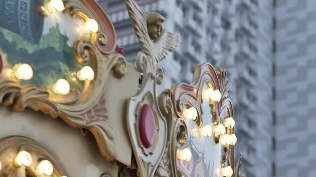 Spinning carousel with glowing bulbs and an angel decoration, bringing fun to the city