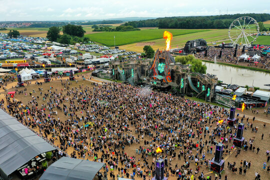Herzogenaurach, Germany - 26 July 2025: Aerial view of Open Beatz Festival with a large crowd, a main stage featuring fire effects, and a ferris wheel in the background.