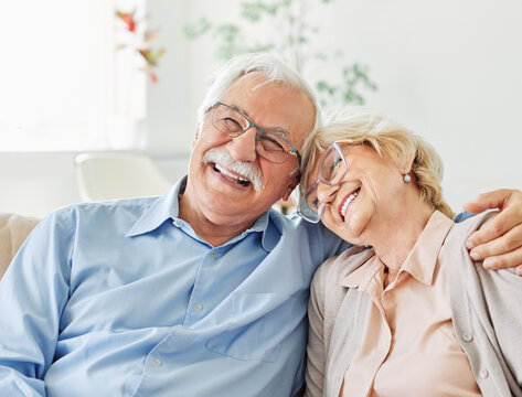 Portrait of a happy senior couple embracing hugging and having fun at home