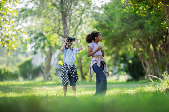 Multicultural Children Exploring Nature with Binoculars During Outdoor Eco Education Activity