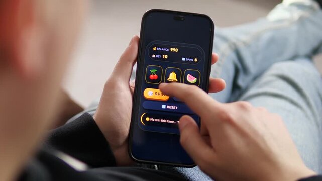Lose yourself in the game. Cinematic shot of a person playing a mobile slot machine app. High-quality UI showing spin attempts and no win result. Perfect for gambling addiction awareness, casino