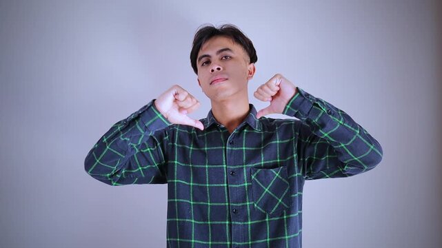 Arrogant Asian man pointing at himself while looking confidently at the camera, expressing pride and self-importance in a video studio shot