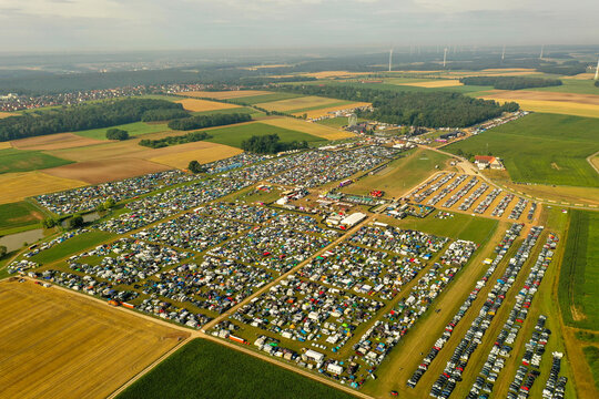 Herzogenaurach, Germany - 24 July 2025: Aerial view of the Open Beatz Festival campsite with thousands of tents and parked cars spread across green fields in a rural landscape.