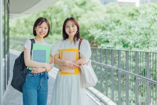 大学のキャンパスを歩く女子大生二人組