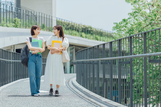 大学のキャンパスを歩く女子大生二人組