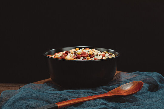 Laba Porridge Ingredients in Black Bowl with Wooden Spoon