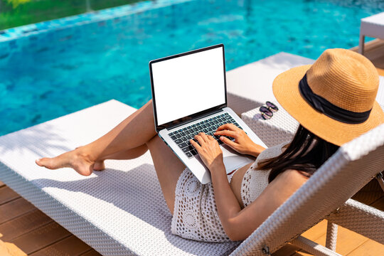 Young woman freelancer traveler working online using laptop while traveling on summer vacation, Freelance and workation concept