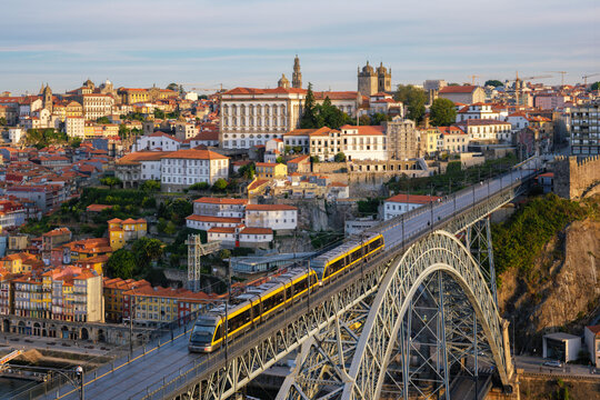 Sunrise morning view of Porto and Ribeira with a tram on Dom Luis I Bridge above the Douro River and its steel arch in Portugal