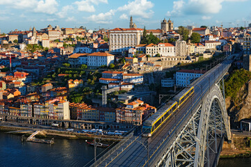Obraz premium Elevated view of Porto and Ribeira with a tram on Dom Luis I Bridge and river boats below on the Douro River in Portugal