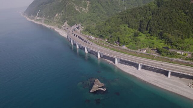 【サイドビュー追従・パン】親不知海岸の高架橋を走る車とエメラルドグリーンの日本海