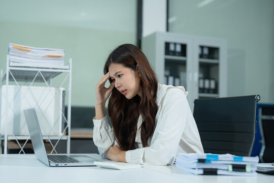 Young stressed Asian businessman working in the office. Businesswoman thinking too much work concept in the office.