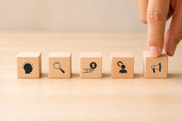 Naklejka premium Digital marketing funnel concept: winning new customers with marketing strategies ; wooden cubes with stage awareness, consideration, purchase, retention and businessman hold cube with advocacy icon.