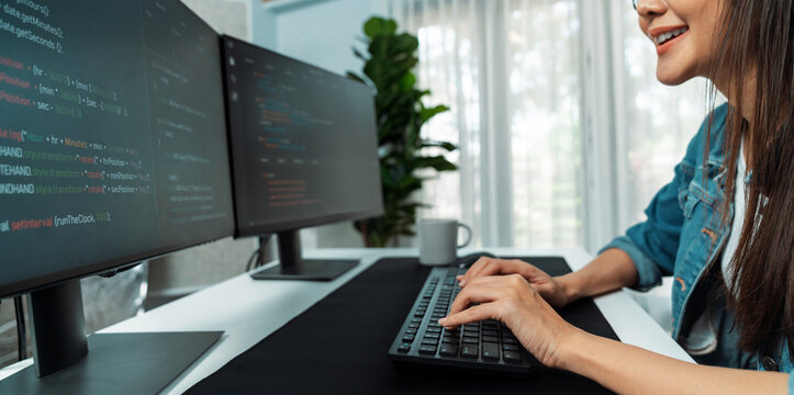 Young Asian in IT developer creating with typing online information on pc with coding program data of website application, wearing jeans shirt. surrounded by safety analysis two screens. Stratagem.