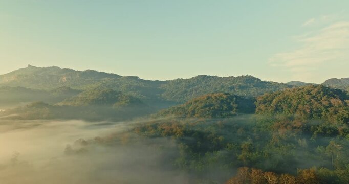 The spectacular landscape of Thi Lor Su Waterfall features a wide waterfall stream, sea of mist, mountain peaks, and vibrant tropical rainforest, creating one of the most beautiful natural 