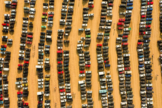Herzogenaurach, Germany - 22 July 2022: Aerial view of the Open Beatz Festival parking lot with rows of colorful cars parked on a dry field during sunset.