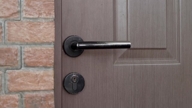 a man closes the door and locks the house when he wants to go out, Close up of man hand locking the house door.
