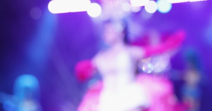 Blurred Thai dance showgirl performing on stage with colorful lights, creating an artistic entertainment and nightlife atmosphere