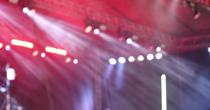 Colorful concert stage lights with dramatic beams and smoke at a live event. Vibrant nightlife, music festival, party, and entertainment atmosphere background