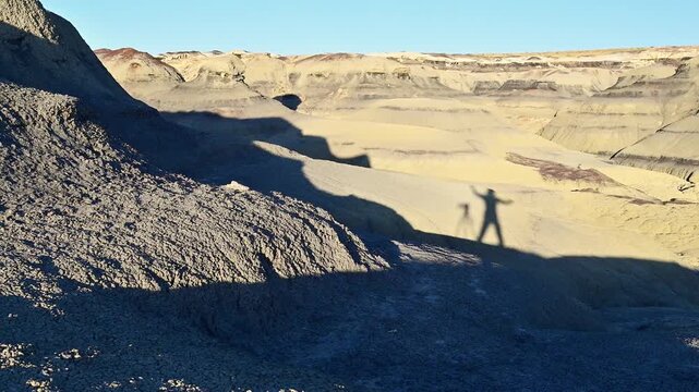 Shadow of a jumping human on yellow clay soil. Bisti De-Na-Zin Wilderness Area