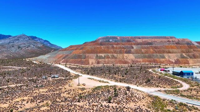 Flyover the highway with moving cars in the deserted area. Heading to the rare-earth element mine in the desert of California, USA.
