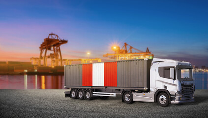 Container Truck at Port Dusk: A large container truck, its trailer adorned with the flag of Peru, stands ready for transport at a bustling port as dusk settles. © bao