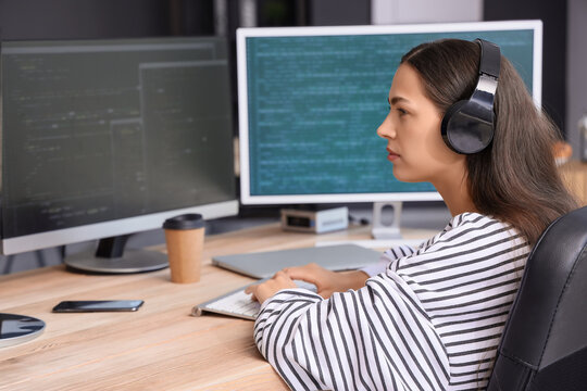 Pretty young female programmer working in office