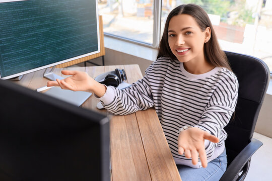 Confused young female programmer working in office
