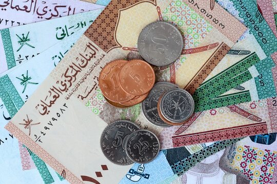 Omani rial money bills and coins on table. Oman cash of OMR currency close up