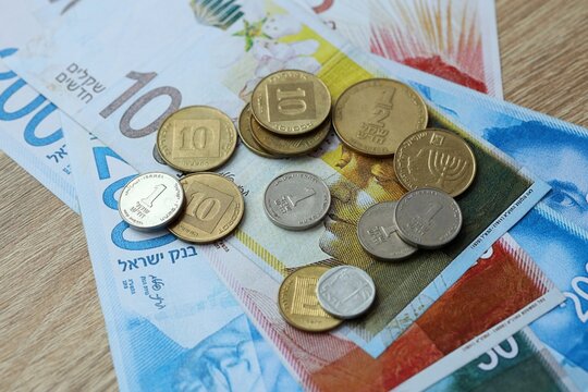 Israeli shekel money bills and coins on table. Israel cash of ILS currency close up